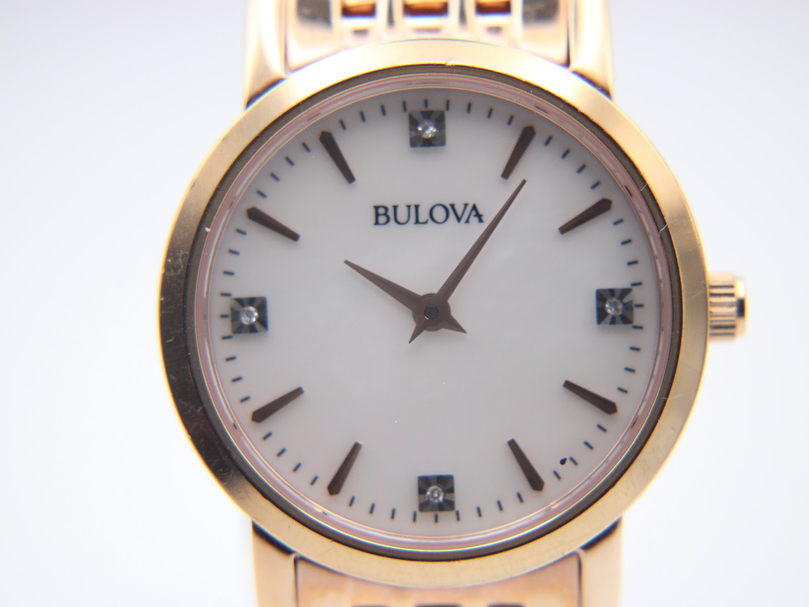 Close-up of the Bulova watch dial, clearly showing the mother of pearl texture, diamond indices, and rose gold-tone hands.