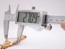Digital caliper measuring the case diameter of the watch, showing an exact reading of 27.09mm.