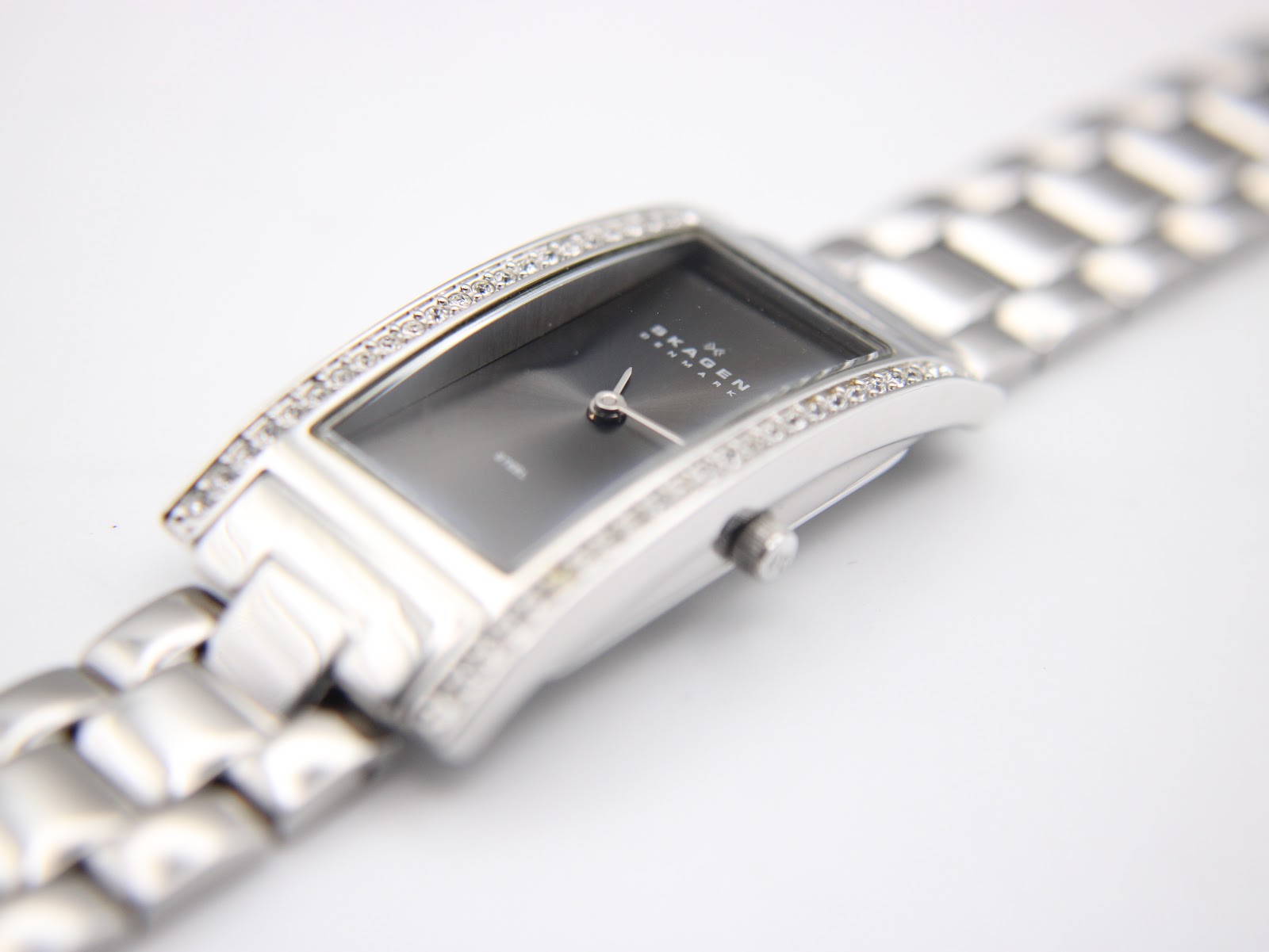 Angled close-up of the watch case and bracelet, focusing on the crystal-set rails and the polished finish of the stainless steel links.
