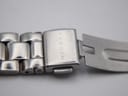 Close-up of the stainless steel bracelet's fold-over clasp, clearly showing the "SKAGEN" brand name engraved vertically.