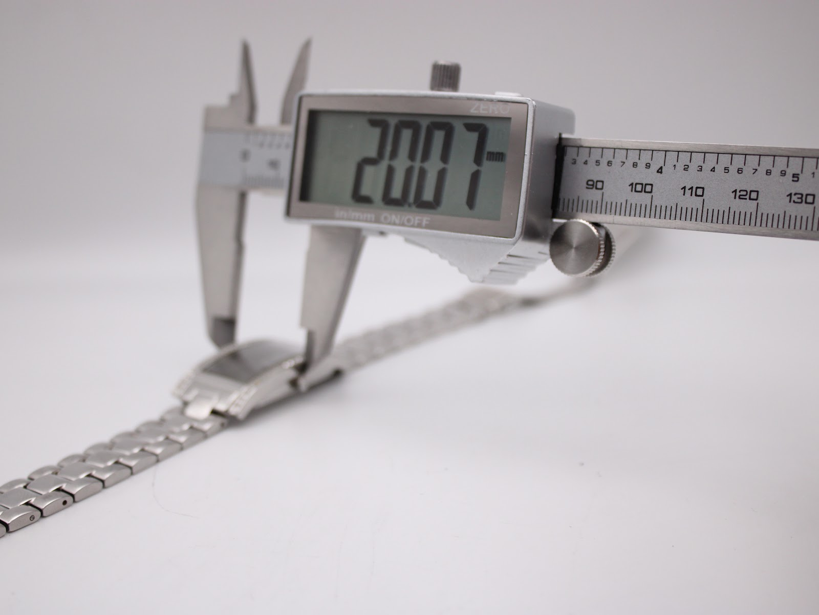 Digital caliper measuring the case width of the Skagen watch, displaying a precise measurement of 20.07mm.