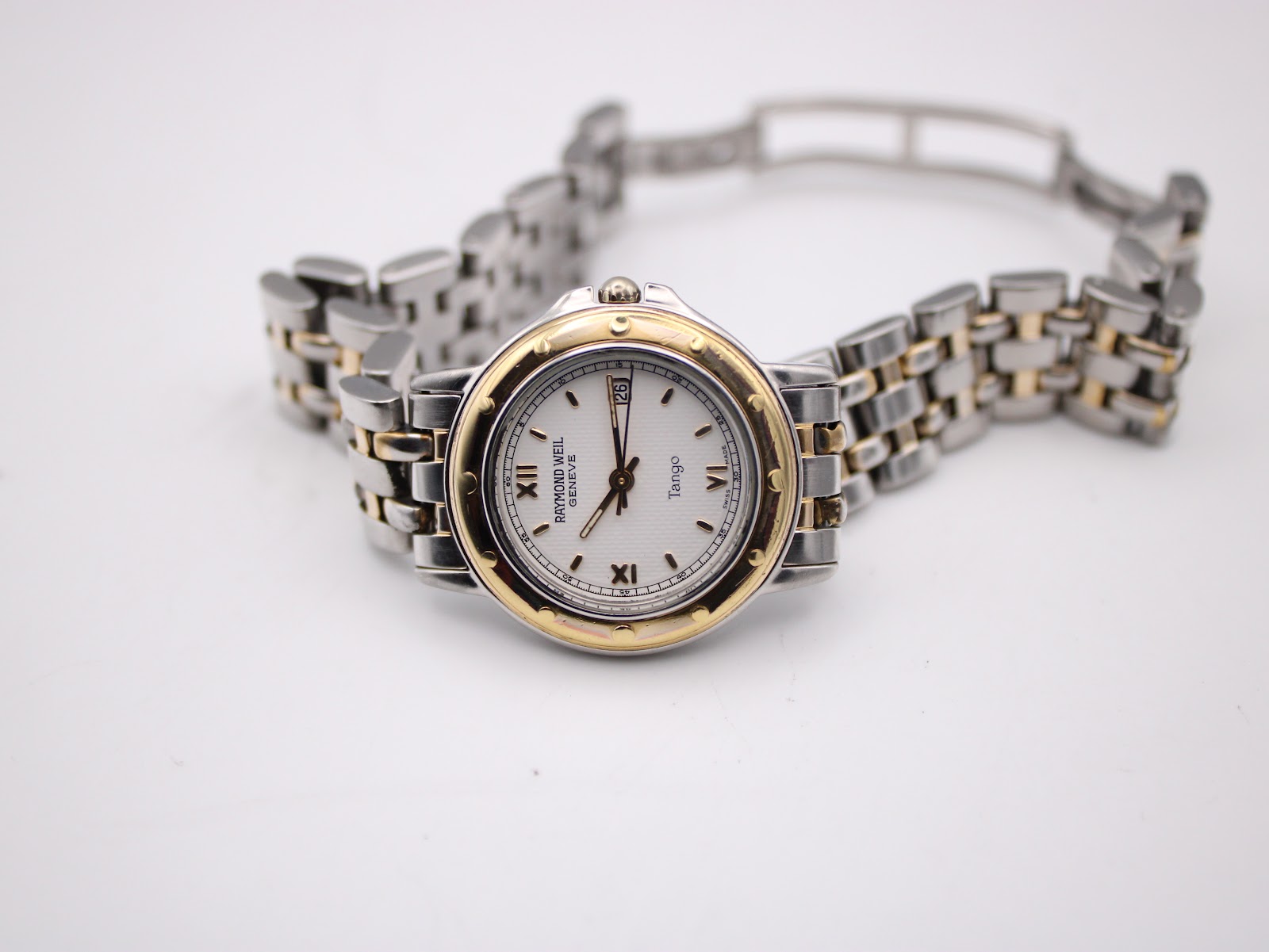 Top-down view of the Raymond Weil Tango watch with its two-tone bracelet laid flat.