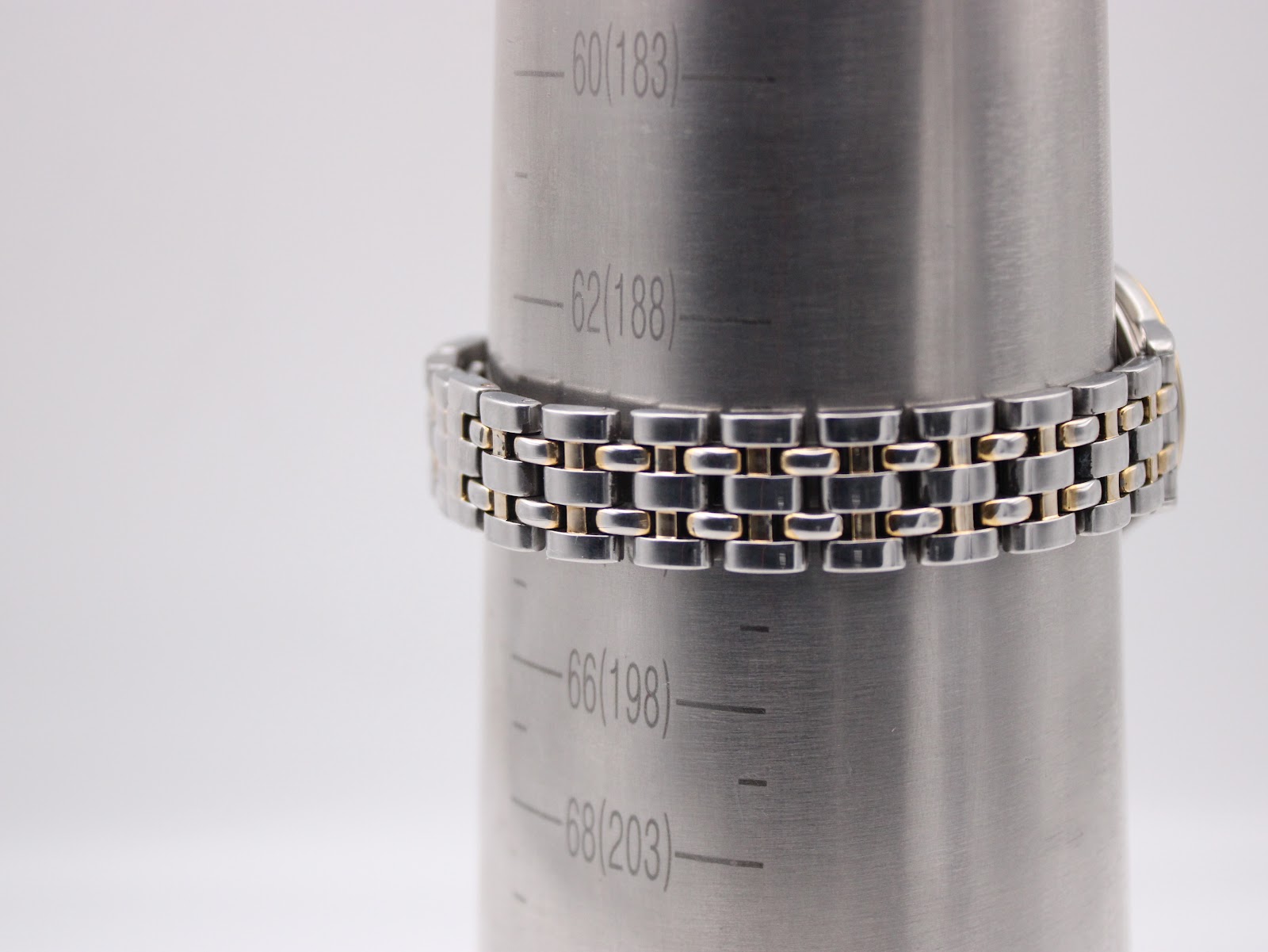 The watch's two-tone bracelet wrapped around a metal wrist sizing gauge, indicating a fit of approximately 190mm.