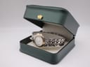 The Raymond Weil Tango watch presented in a dark green generic display box, open with a gold crown emblem.