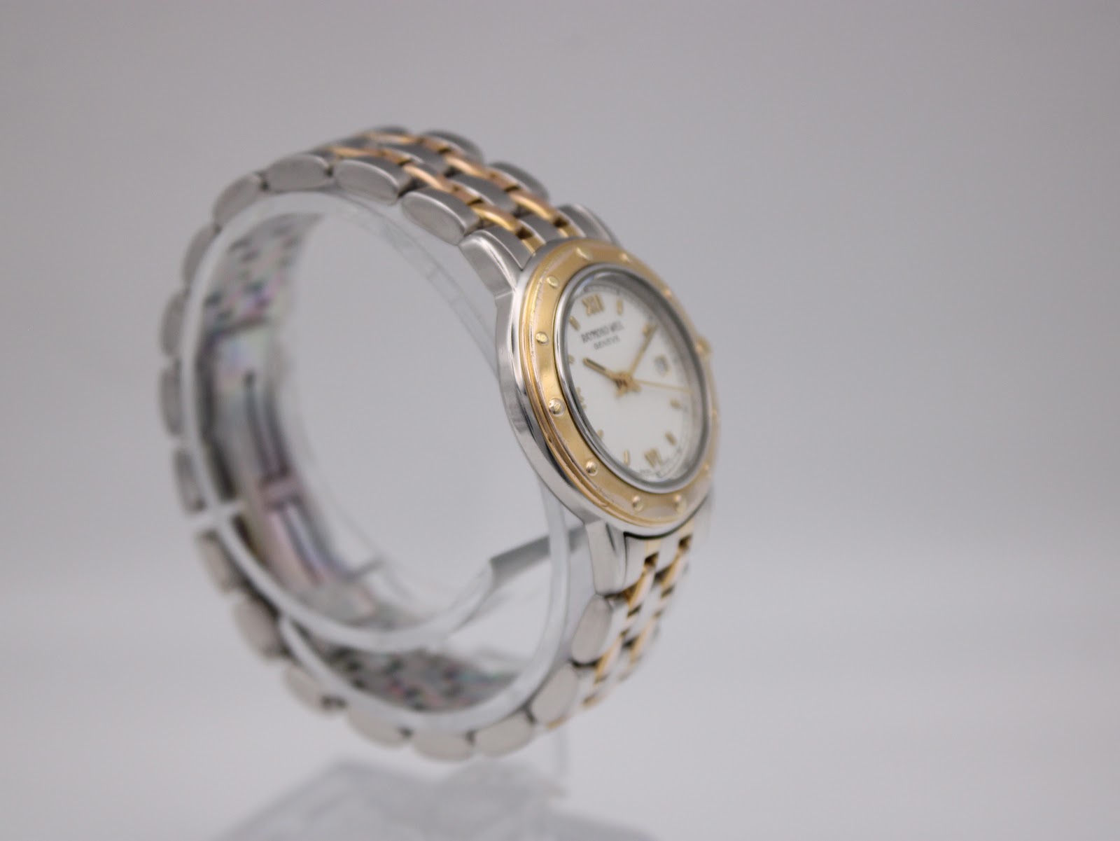Angled side view of the Raymond Weil Tango watch, highlighting the two-tone bracelet and case profile.