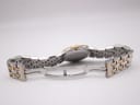 Rear view of the open two-tone bracelet and deployant clasp, showing the case back and bracelet links.