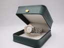 Raymond Weil Tango watch resting inside an open dark green presentation box.