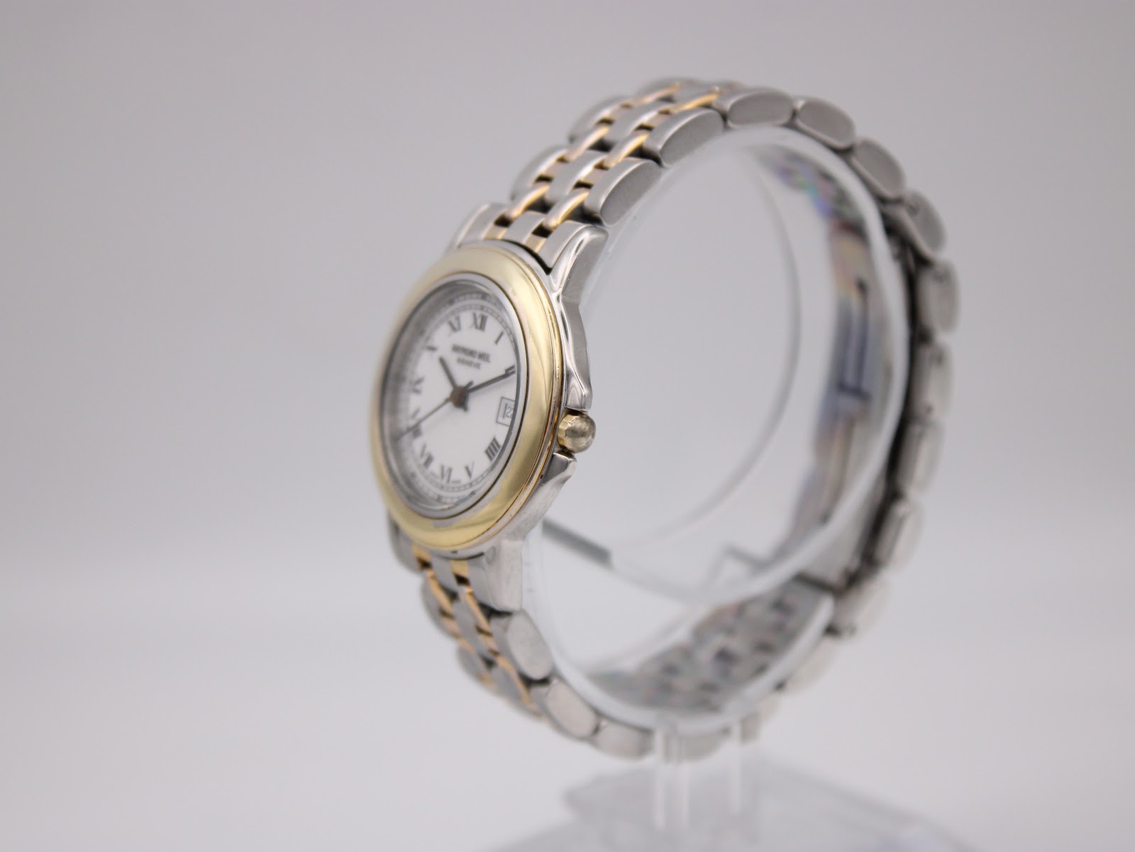 Angled side view of the Raymond Weil Genève 5360, showing the two-tone case and bracelet on a stand.