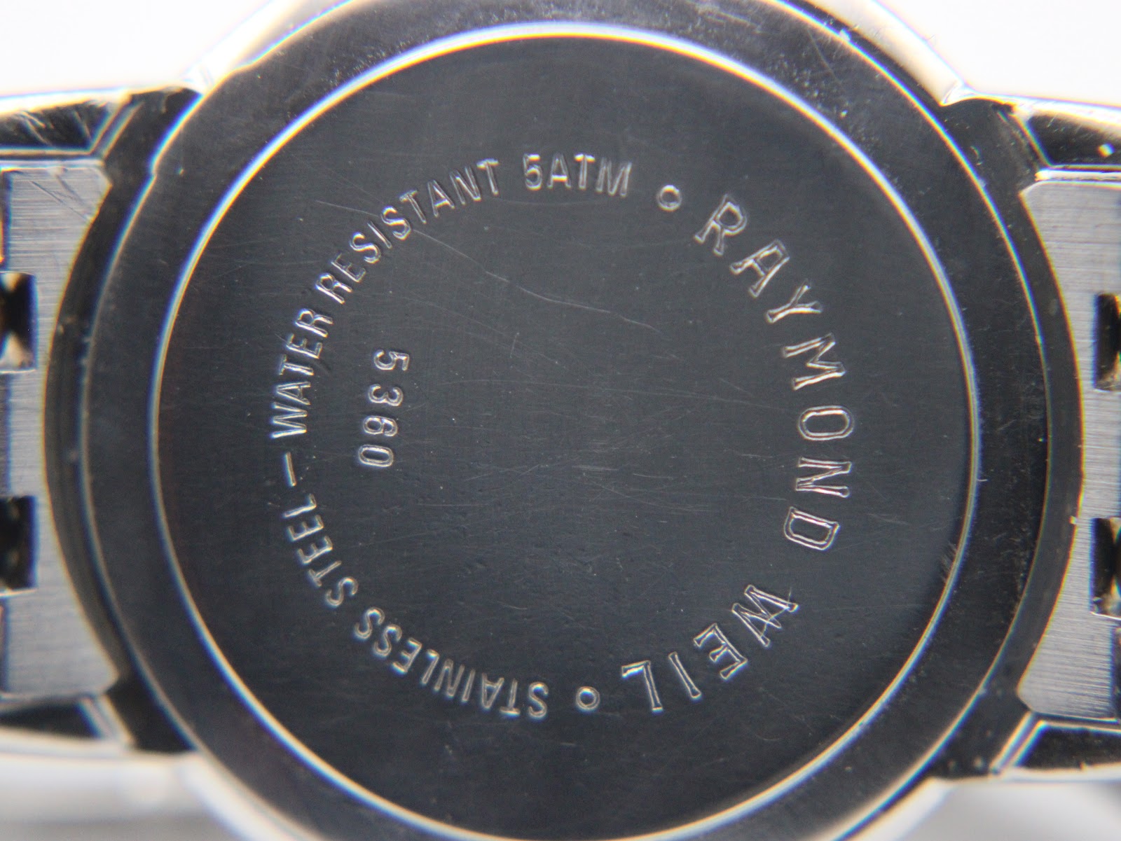 Close-up of the stainless steel case back, showing 'Raymond Weil Genève 5360 Water Resistant 5ATM' engraving.