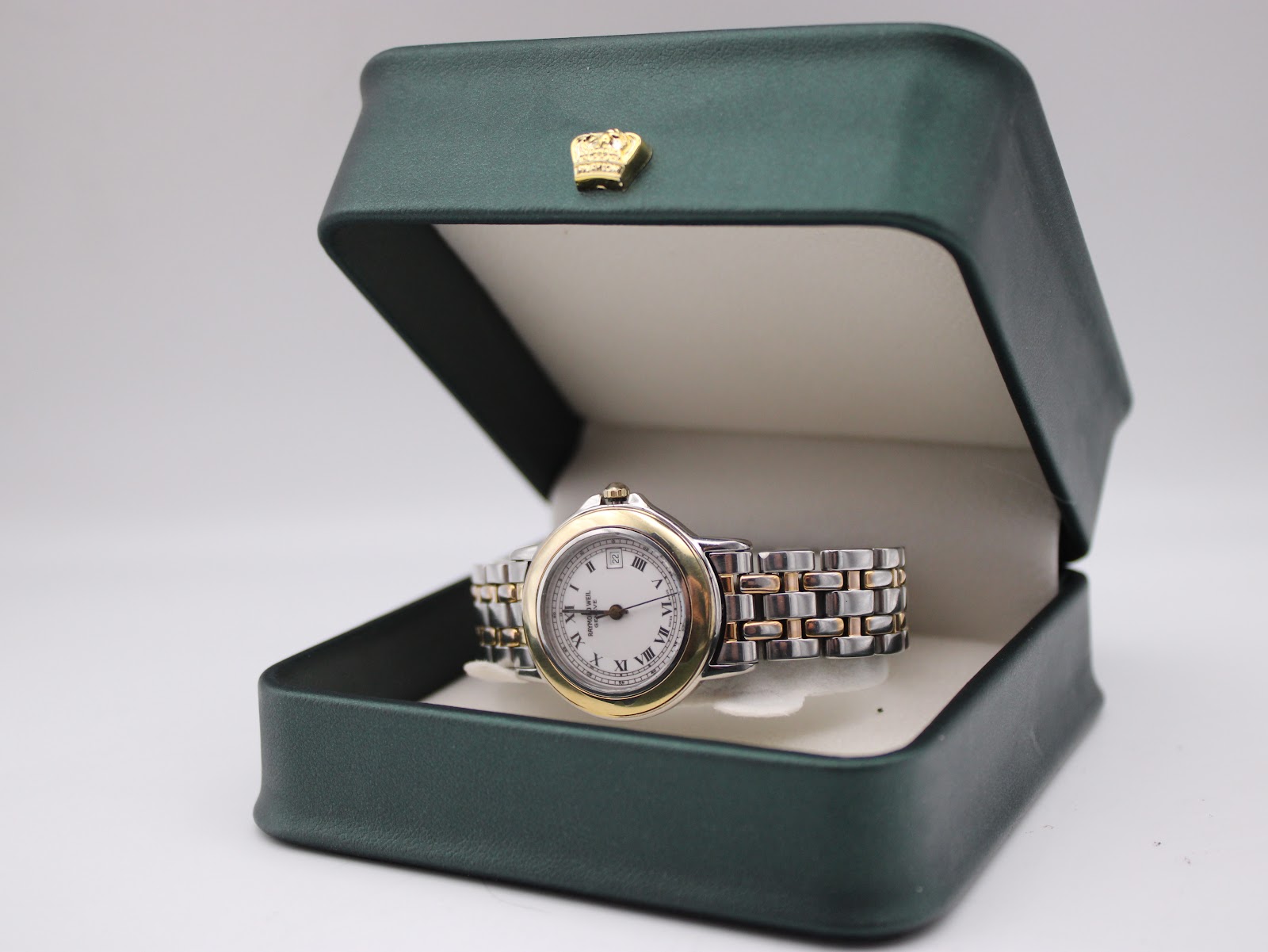 The Raymond Weil Genève 5360 watch presented inside an open dark green box.