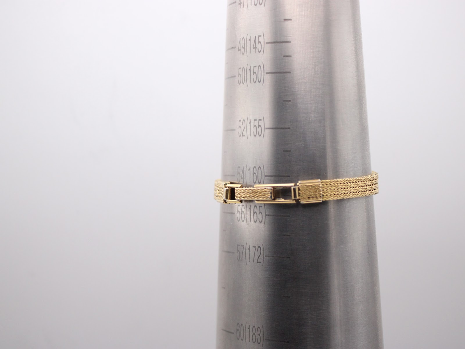 The gold woven bracelet of the Raymond Weil watch displayed on a wrist sizing cone, indicating a wrist fit of approximately 160mm.