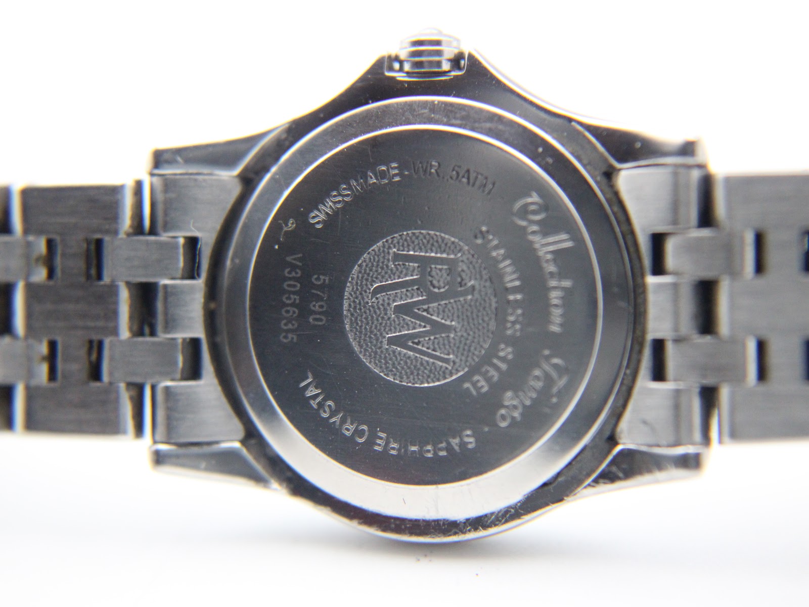 Close-up of the watch case back, detailing engravings like 'Raymond Weil', 'Tango', 'Swiss Made WR 5ATM', 'Stainless Steel', 'Sapphire Crystal', and serial number V305635.