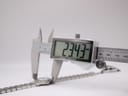 Digital caliper measuring the Raymond Weil Tango watch case diameter, displaying an exact measurement of 23.43mm.