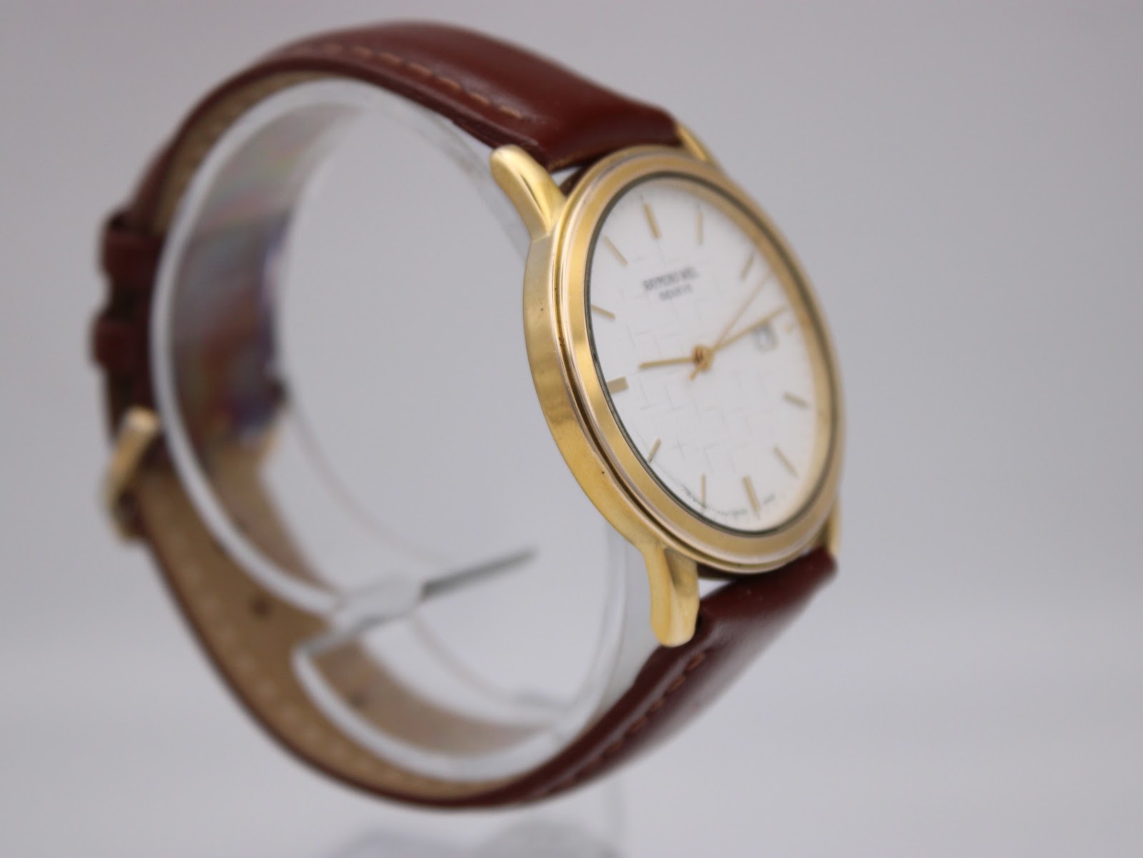 Other angled side view of the Raymond Weil 5548 on a display stand, highlighting the slim case.
