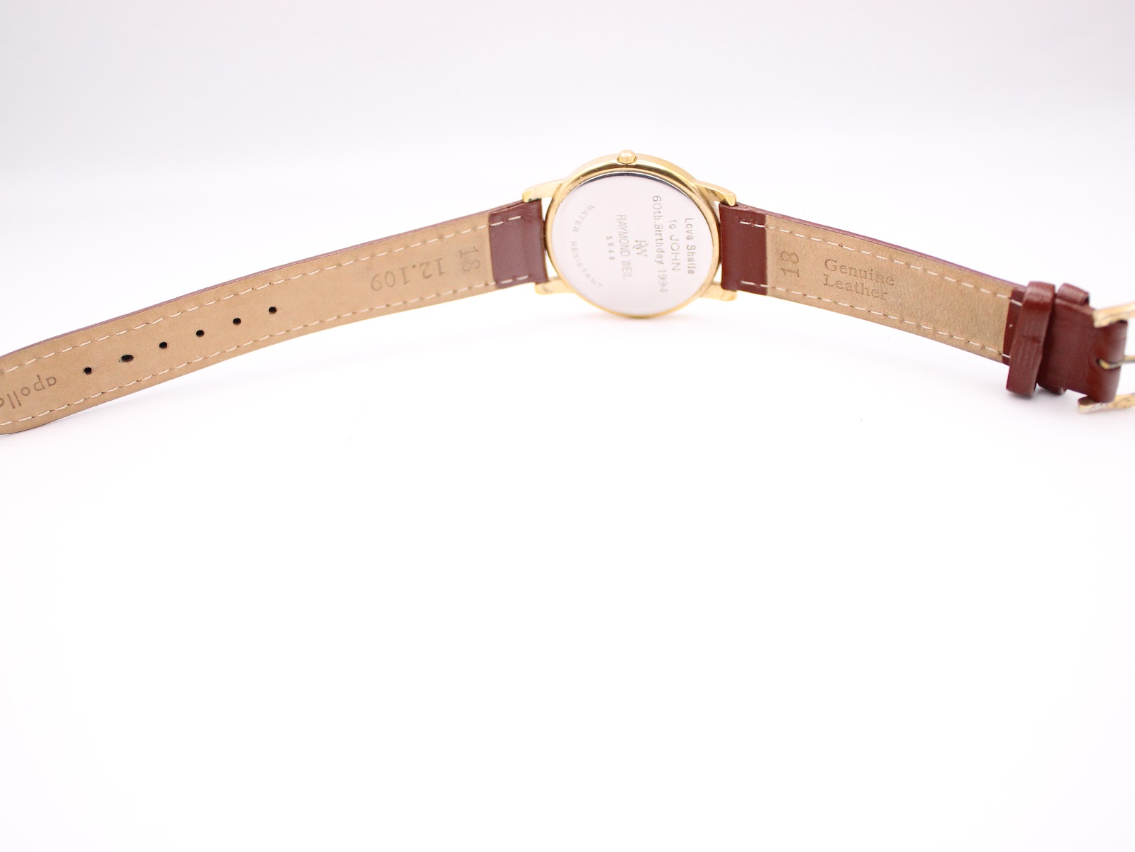 Rear view of the watch and strap laid flat, showing "Genuine Leather" and "18" mark on the strap.
