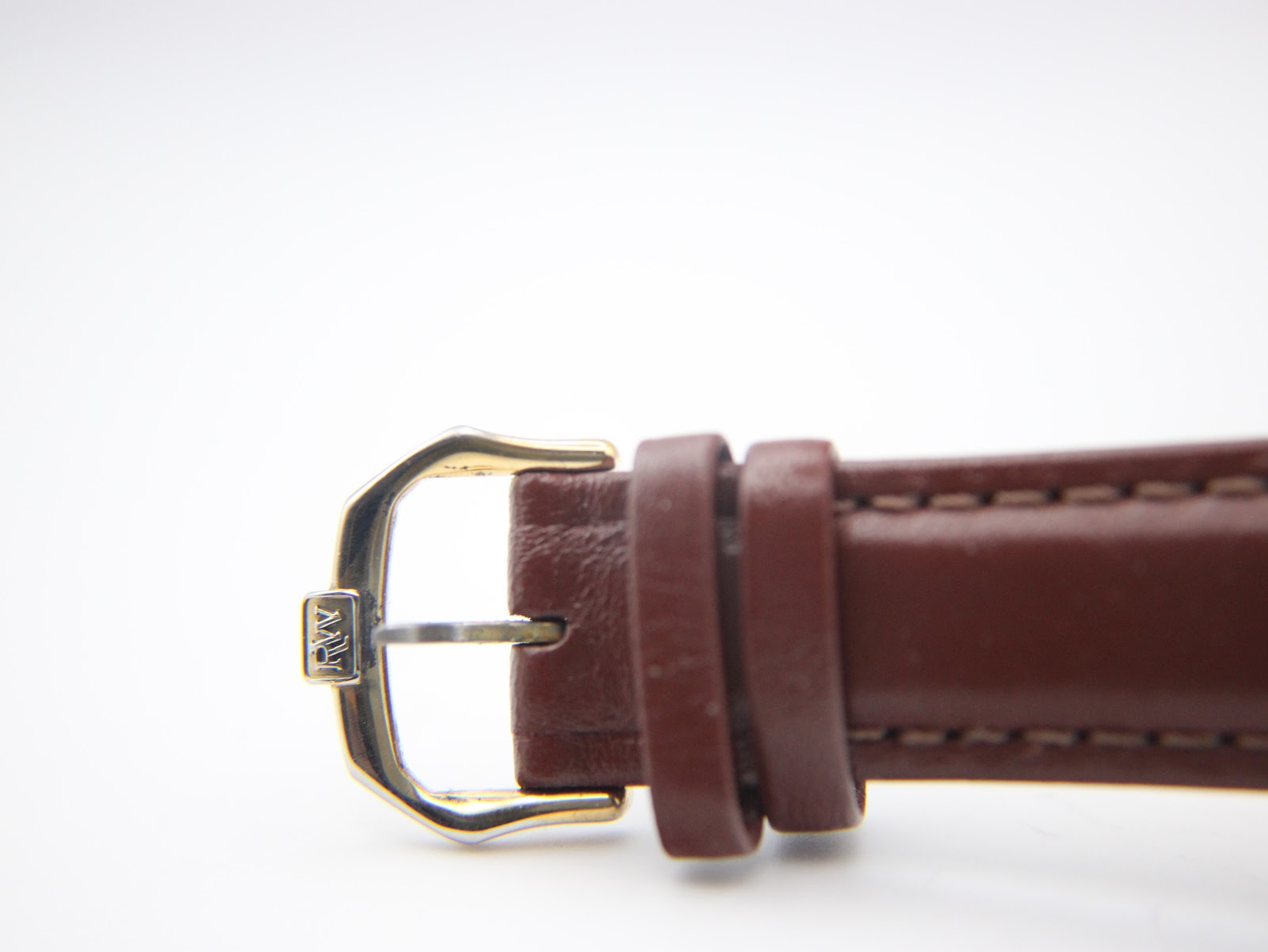 Close-up of the gold tone buckle, clearly showing the engraved "RW" logo.