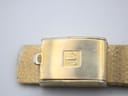 Close-up of the gold-tone integrated bracelet's signed Tissot clasp.