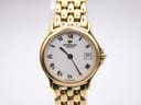 Close-up front view of the Raymond Weil Genève white dial with prominent gold Roman numerals, a date window at 3 o'clock, and gold tone hands.