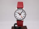Front view of Mondaine Swiss railways watch with white dial, black markers, and red seconds hand on a red leather strap.