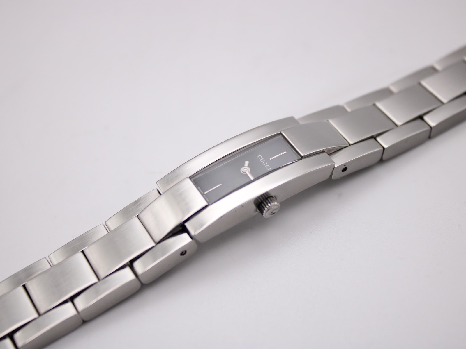 Top-down view of the Gucci 4600L watch with its integrated stainless steel bracelet laid flat, showcasing the full length.