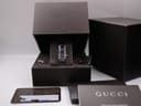 Gucci 4600L watch presented in its original black box, with the authenticity card, manual, and extra bracelet links visible.