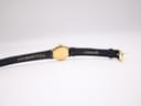 Bottom-up view of the watch laid flat, revealing the inner lining of the black leather strap with 'R 7/16 ALLIGATOR CALF' and 'KREISLER' markings, along with the gold-tone buckle.