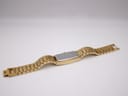 Angled rear view of the extended watch, highlighting the stainless steel case back and the full length of the gold-tone bracelet.