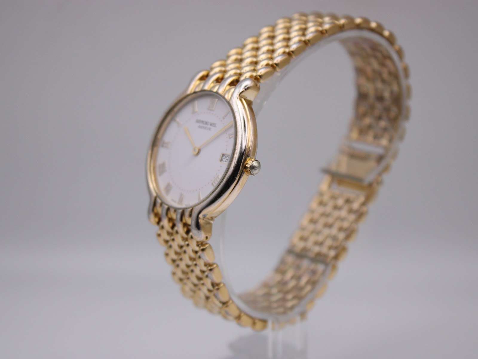 Angled side view of the Raymond Weil watch, showcasing the rounded case profile and the integrated two-tone bracelet.