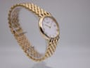 Another angled side view of the Raymond Weil watch, highlighting the case and the textured gold-tone links of the bracelet.