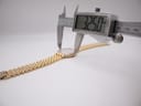 A digital caliper displaying 32.50mm, measuring the case diameter of the Raymond Weil watch.