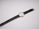 Full length view of the Raymond Weil watch with its brown crocodile-embossed leather strap laid flat on a white background.