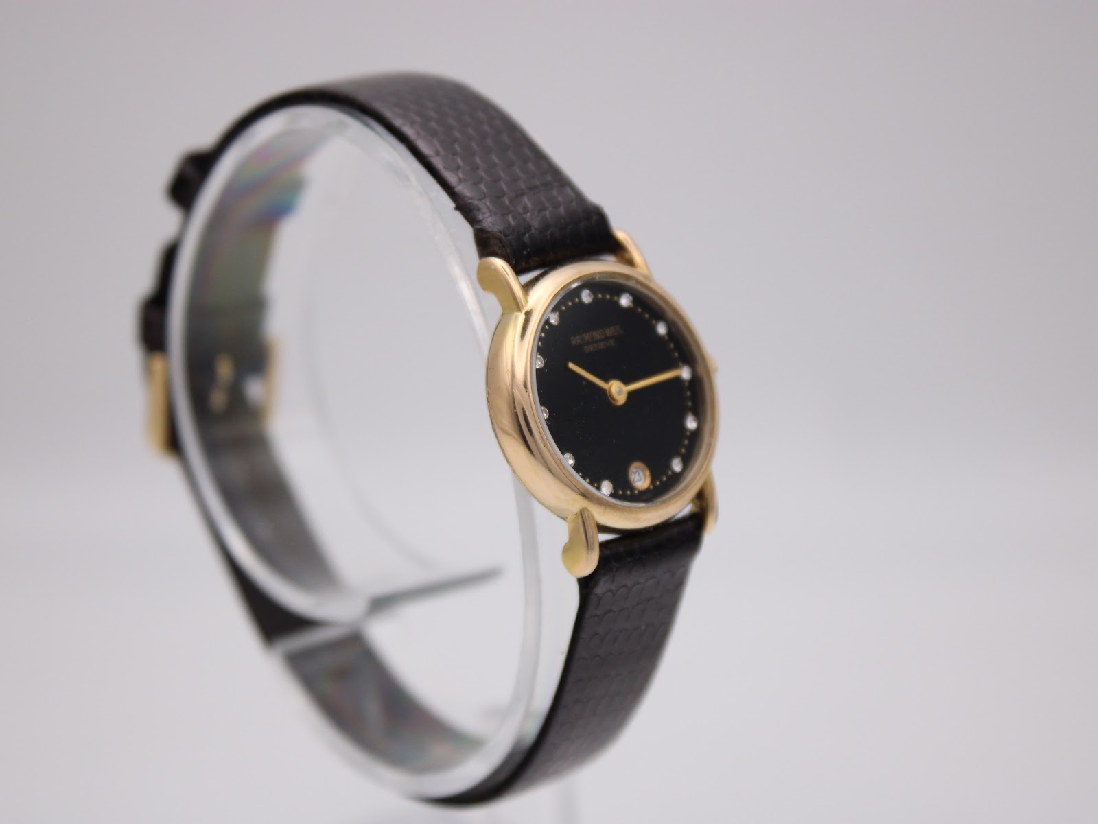 Another angled view of the Raymond Weil Geneve timepiece, highlighting the refined case shape and the subtle shimmer of the black sunburst dial.
