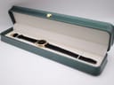 The Raymond Weil Geneve watch nestled within its original green presentation box with cream-coloured interior.