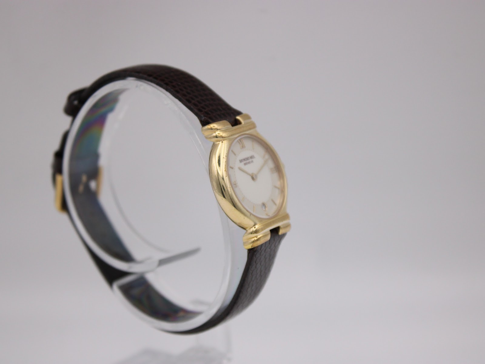 Angled side view of the watch, highlighting the gold electroplated case and the shape of the lugs.