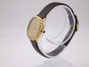 Side profile of the Raymond Weil watch, highlighting the gold tone fluted bezel and dark brown leather strap.