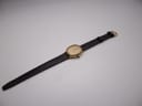 Full length view of the Raymond Weil watch and dark brown leather strap, lying flat against a white background.