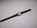 Back view of the watch and strap, showing the stainless steel case back and 'REAL LEATHER' stamped on the strap.