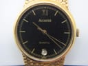 Extreme close-up of the Accurist watch dial, showing 'Accurist', 'QUARTZ', Roman numeral XII, and date window.