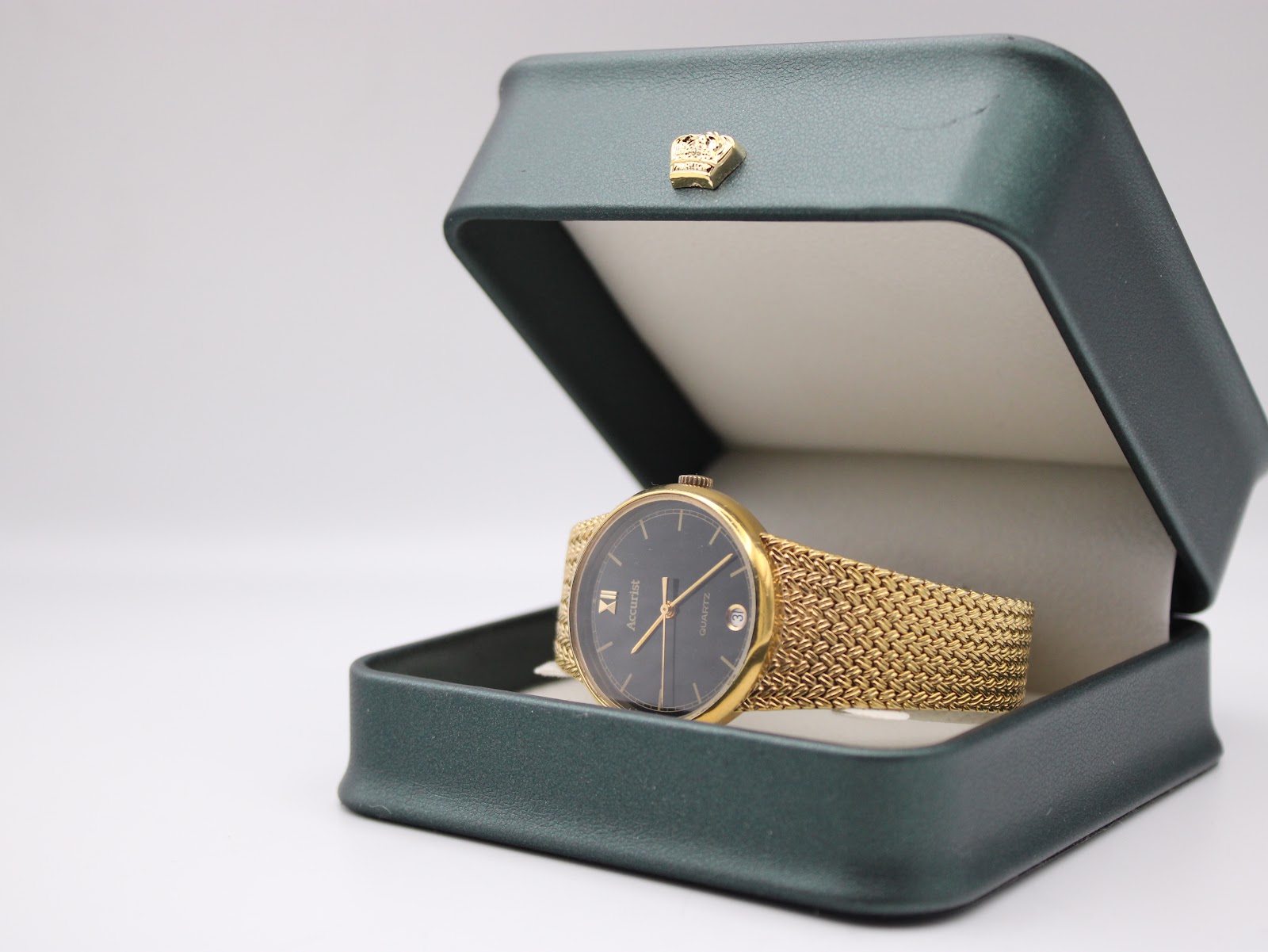 Accurist watch displayed in an open dark green presentation box on a white background.