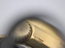 Close-up of the gold-plated case side near the crown, showing a small hallmark or engraving.