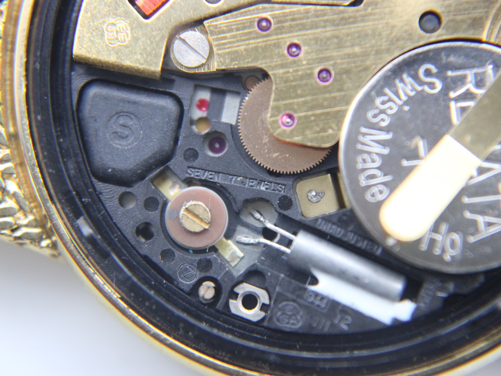 Extreme close-up of the Accurist quartz movement showing 'seven jewels' and internal components.