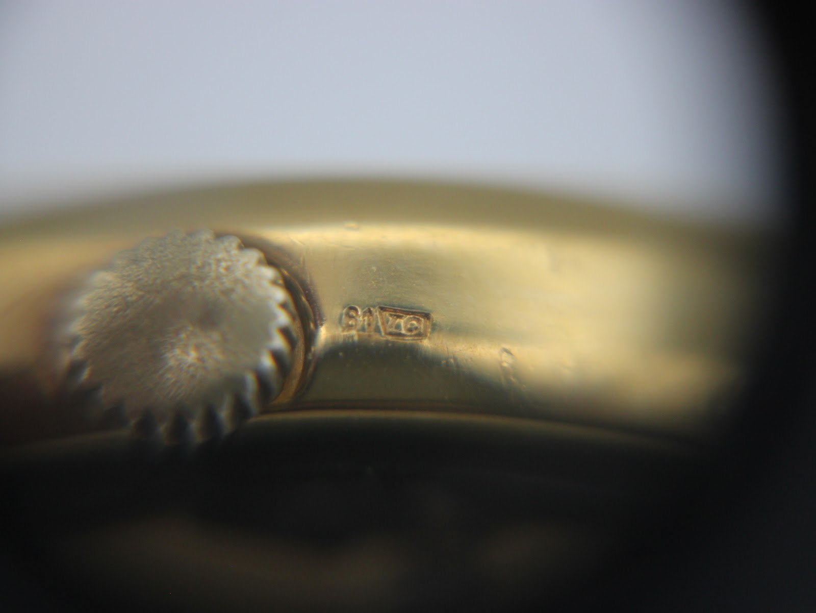 Close-up of the crown and case side, showing another view of the small hallmark or engraving.