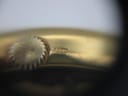 Close-up of the crown and case side, showing another view of the small hallmark or engraving.