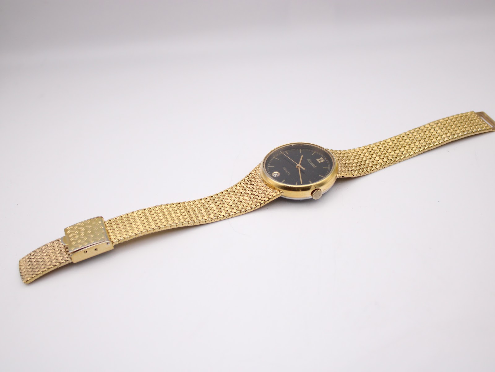 Full length view of the Accurist watch and gold mesh bracelet laid flat.