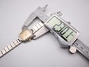 Digital caliper measuring the watch case, displaying a precise diameter of 23.07mm.