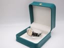 Dunhill Millennium watch displayed inside an open, empty teal watch box.