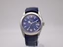 Front view of Rotary 10304 watch with navy blue dial, silver case, and blue leather strap on a stand.