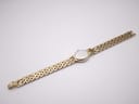 Rear view of the full watch and integrated gold-tone steel bracelet laid flat, showing the case back and bracelet underside.