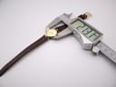 A digital caliper measuring the case diameter of the Gucci watch, displaying a precise measurement of 23.11 mm.