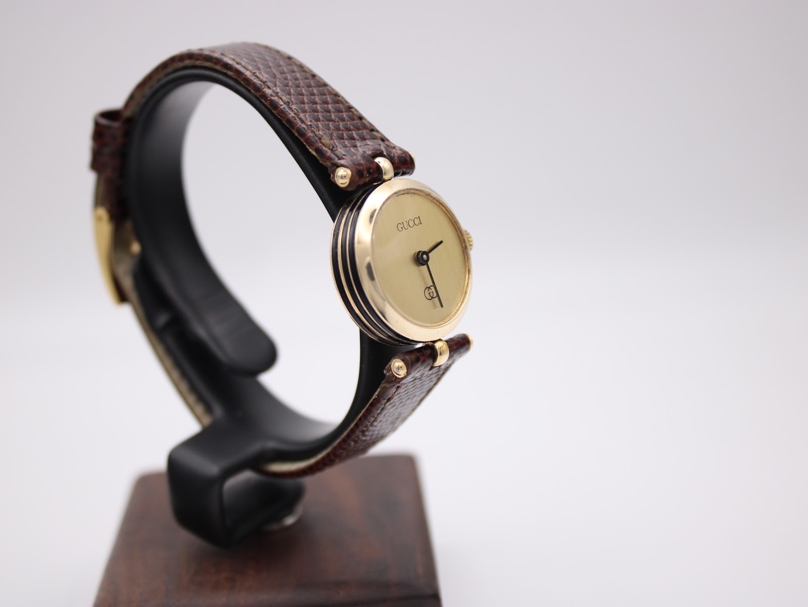 Another angled view of the Gucci 2000L watch, showing the elegant profile of the gold case and the texture of the strap.